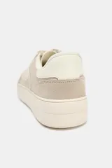 Zapatillas deportivas color beige, con cuerpo en combinación de materiales y cierre mediante cordones. La altura de la suela es de 3 cm.