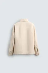 Sobrecamisa color beige de algodón con estructura canvas, corte relaxed fit, cuello solapa, manga larga con puño abotonado, bolsillos de plastrón frontales y cierre frontal con botones.