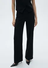 Pantalón negro de corte recto y tiro medio, con cintura elástica y costuras decorativas. Ideal para looks de oficina.