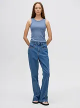 Pantalón de jean azul de tiro alto y corte oxford con apliques metálicos en bolsillos y laterales.