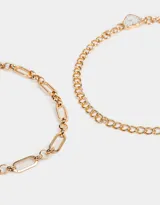 Set de dos chokers dorados con diferentes cadenas de eslabones. Uno de los chokers tiene un dije de reloj con forma de corazón.