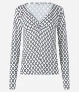 Blusa de viscolycra blanca con estampado de cadenas negras, escote en V retorcido y mangas largas.