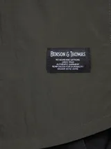 Camisa verde militar de manga larga con cierre de botones, cuello clásico y dos bolsillos frontales con solapa.