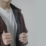 Campera negra de pana con cuello camisero, cierre frontal con botones a presión, dos bolsillos de parche en el pecho y corte recto.