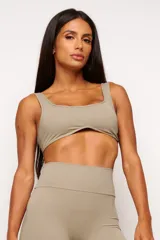 Top deportivo gris con escote cuadrado, breteles anchos y calce ajustado. Incluye forro interno y apertura para almohadilla removible.