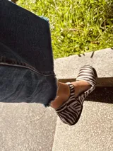 Zapatos tipo Mary Jane con estampado de cebra en pelo sintético, con correa sobre el empeine y hebilla metálica.