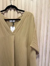 Blusa color beige de escote en V y mangas cortas.
