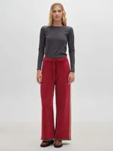 Pantalón ancho color marrón óxido, de textura tipo terciopelo con pespuntes a los lados.