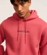 Hoodie color salmón de algodón con felpa, corte comfort, capucha con cordón ajustable, manga larga, bolsillo canguro, barras ajustadas y estampa lettering "Synthetic escape" en frente y espalda.