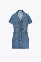 Vestido corto de denim azul, con cuello solapa, escote en pico, manga corta, bolsillos delanteros y cierre frontal con botones metálicos.