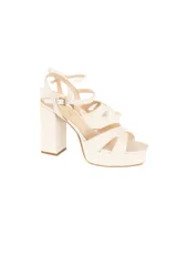 Sandalias de cuero color blanco hueso, con plataforma y tacón ancho de 10 cm. Presentan tiras cruzadas envolventes y hebilla dorada lateral.