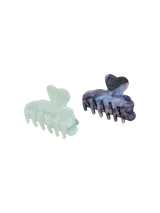 Pack de dos pinzas para el cabello con cierre de clip, una color celeste marmolado y otra con estampado de galaxia.