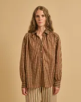 Camisa marrón con estampado de líneas verticales color crema, corte holgado y cuello clásico.
