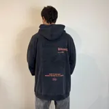 Canguro negro con capucha y corte oversize. Estampado en la espalda con el texto "Underwave Brand", un cangrejo y la frase "Surf N' Destroy".