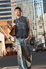 Musculosa negra con cuello redondo y sisas amplias. Estampado frontal con texto en color gris. Corte oversized.