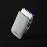 Billetera doble de tela X-Pac negra con doble caja de aluminio incorporado con sistema de deslizamiento para tarjetas. Tiene espacio para 10 tarjetas, 2 tarjetas adicionales en los bolsillos laterales de cuero, espacio para libreta de conducir y de propiedad, y sección interna para llevar hasta 5 billetes.