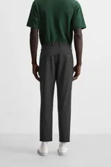 Pantalón slim fit negro confeccionado en tejido con elasticidad en ambas direcciones. Cuenta con bolsillos frontales y traseros de vivo con botón. Cierre frontal con cremallera y botón.