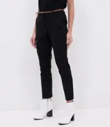 Pantalón cigarrete negro de algodón con cinturón fino marrón.