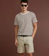 Remera de manga corta con cuello redondo y corte regular. Diseño a rayas horizontales en color marrón sobre fondo beige.