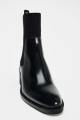 Botín Chelsea negro de charol con caña de tejido elástico acanalado y tacón ancho.