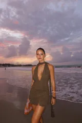 Vestido corto color marrón con brillos, escote halter y espalda descubierta.