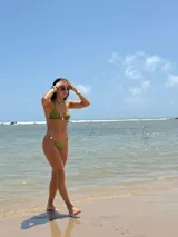 Conjunto de bikini verde con corpiño triangular con detalle de cuentas en el centro y bombacha con tiritas ajustables y detalle de cuentas en los laterales.