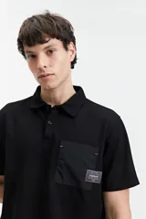 Remera polo negra con bolsillo de nylon en el pecho y logo bordado. Corte regular.