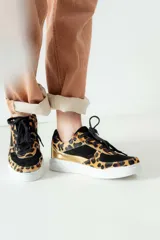 Championes negros con estampado animal print en tonos marrones y dorados.