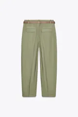 Pantalón blanco de lino, de tiro alto con pinzas delanteras, bolsillos frontales y falsos bolsillos con solapa en la espalda. Incluye cinturón marrón.