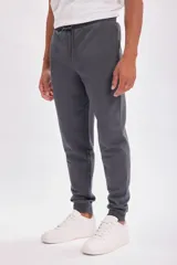 Pantalón deportivo tipo jogger color gris oscuro, con cintura elástica y cordón ajustable.