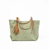 Cartera tipo shopper color verde con textura tipo lino, doble asa de cuero sintético color camel con hebillas ajustables y detalle de borla de flecos de cuero sintético color camel.