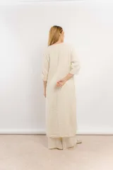 Túnica larga color beige de lino con bordados en el frente y mangas largas.