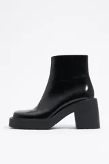 Botín negro de diseño minimalista, con tacón cuadrado y acabado brillante.