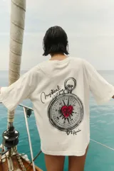 Remerón blanco de algodón con estampa de brújula con un corazón rojo en el centro, la frase "Mystical Voyage" y la firma "By Renée".
