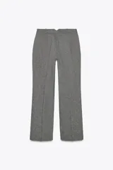 Pantalón de vestir gris jaspeado, de tiro alto, corte recto y largo a la pantorrilla. Cuenta con bolsillos delanteros y cierre frontal con cremallera, botón interior y ganchos metálicos.