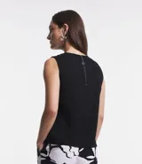 Blusa sin mangas color celeste, de crepé, con cuello redondo, pliegues en uno de los hombros y cierre trasero por cremallera con detalle de aro en el tirador.
