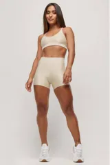 Top deportivo color beige con breteles finos y espalda deportiva.