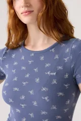 Remera azul con estampado de flores blancas, de corte ajustado y mangas cortas.