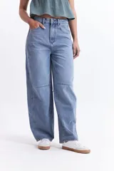 Pantalón jean celeste de tiro medio, corte amplio y redondeado.