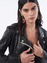 Chaqueta de cuero negra estilo motociclista con cierre cruzado, cuello con solapas y múltiples bolsillos con cremallera.