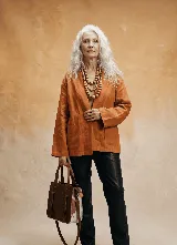 Chaqueta tipo kimono de lino color terracota, con cuello solapa y bolsillos frontales.