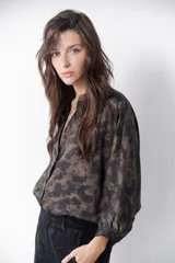Camisa marrón con estampado abstracto en tonos cobre y negro, cuello mao y mangas largas abullonadas con puños elásticos.