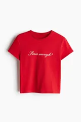 Remera roja de algodón con cuello redondo y estampado frontal con la frase "Paris enough?".