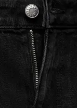 Pantalón de jean negro de tiro medio, corte ajustado hasta la rodilla y acampanado en la parte inferior, con bajo deshilachado.