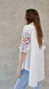 Camisa blanca de algodón con mangas abullonadas y bordados en color bordó, celeste y rosa pastel.