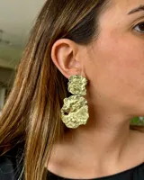 Aros colgantes de bronce con forma irregular y textura rugosa.