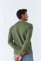 Remera blanca de manga larga con logo gris de la marca Mistral estampado en el pecho.