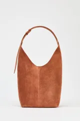 Bolso hobo de gamuza color marrón con asa de hombro ajustable.