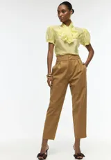 Blusa color amarillo pálido de lyocell, con mangas abullonadas con terminaciones elásticas y lazo XL en el cuello.