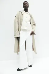 Chaqueta corta color crema en tejido texturizado con cuello clásico y botones metálicos decorativos. De corte ajustado con mangas raglán al codo y bolsillos de parche delanteros. Forrada.